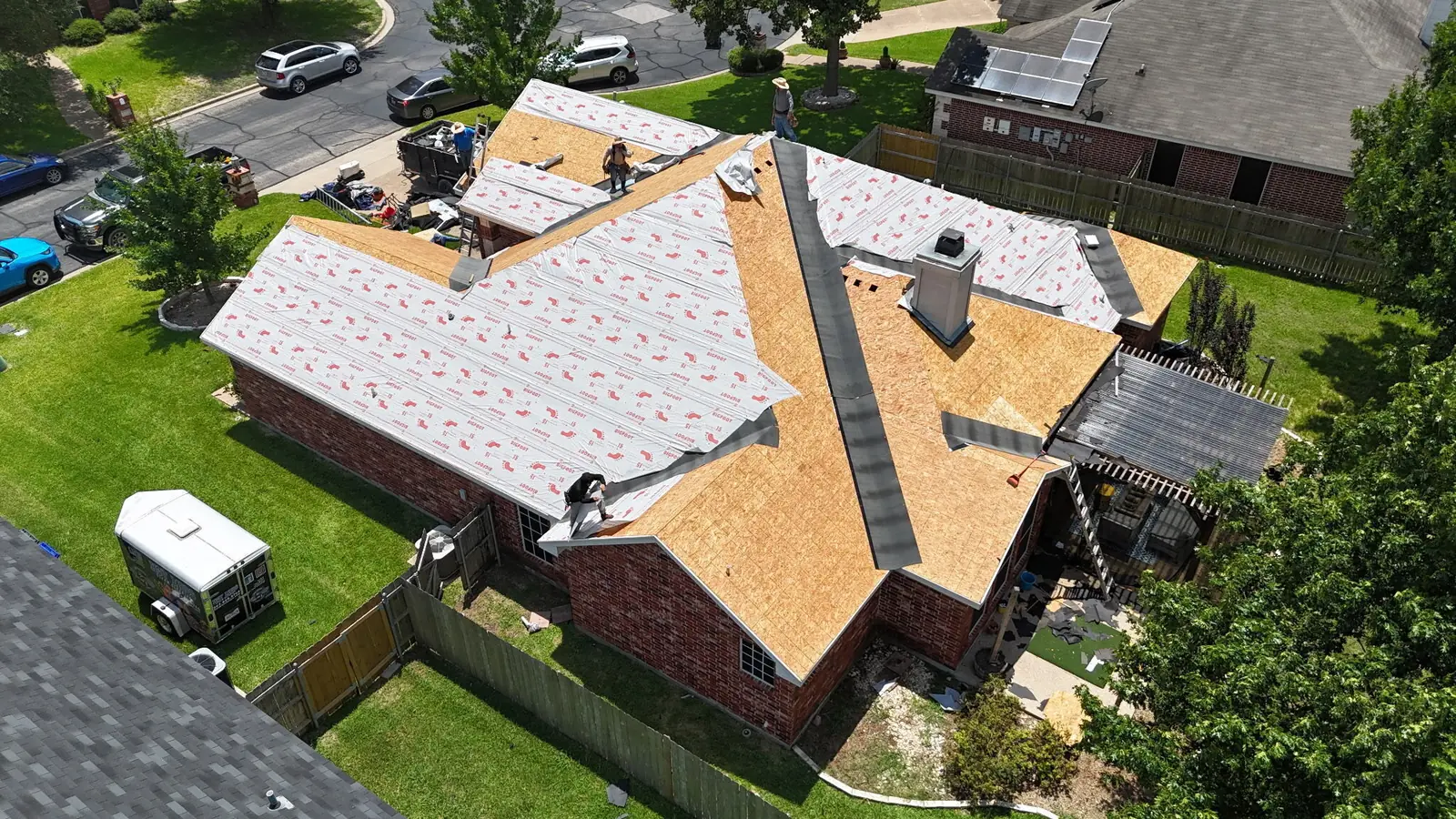 A roof stripped to the decking with underlayment going down, seen from above