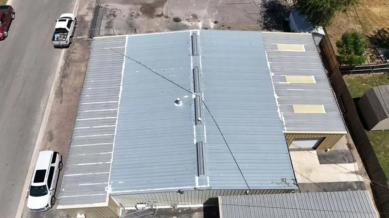 Metal roof on a commercial building beside a street, from above
