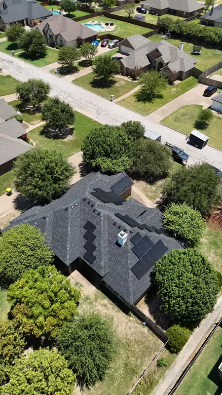 A home with roof mounted solar panels and the street beyond